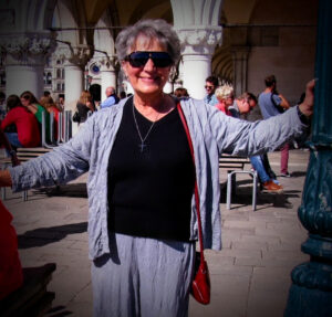Harieklia standing with her arms stretched out and happy while in Venice