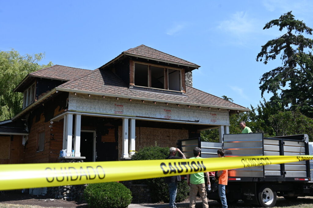 House under construction with contractors in front